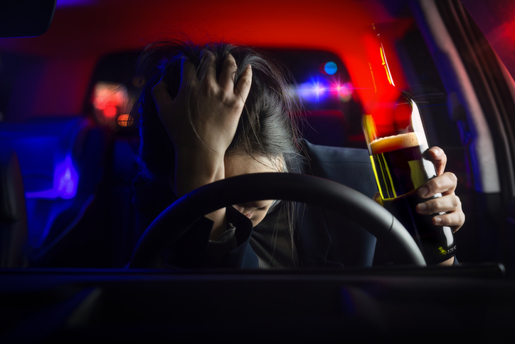 A driver with their head in their hands while pulled over