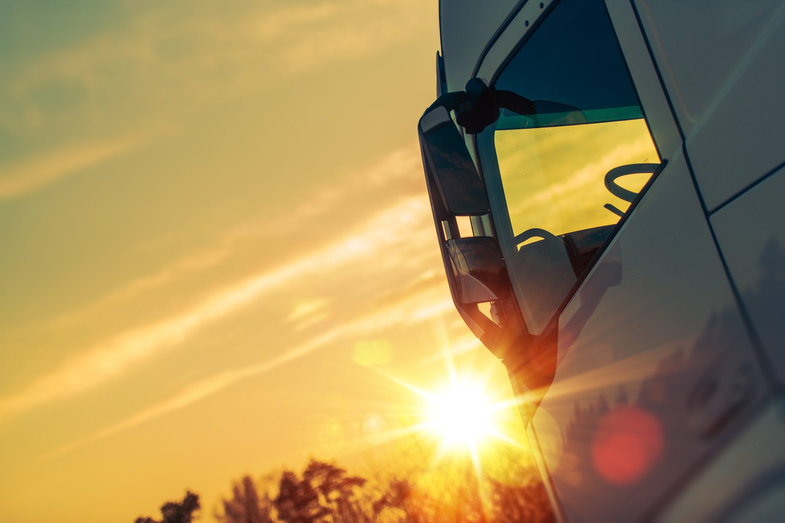 Truck window at sunset with mirror visible, representing a commercial driver facing DUI charges